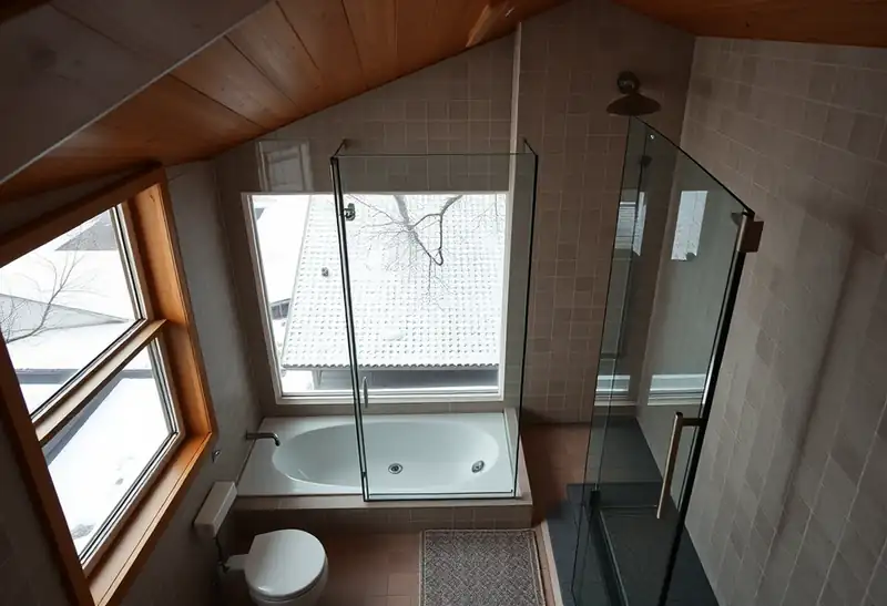 Illustration of modern bathroom with walk-in glass shower and sloped ceiling.